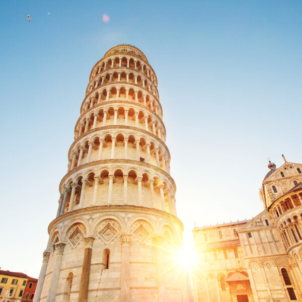 Pisa leaning tower and cathedral basilica at sunrise, Italy.
