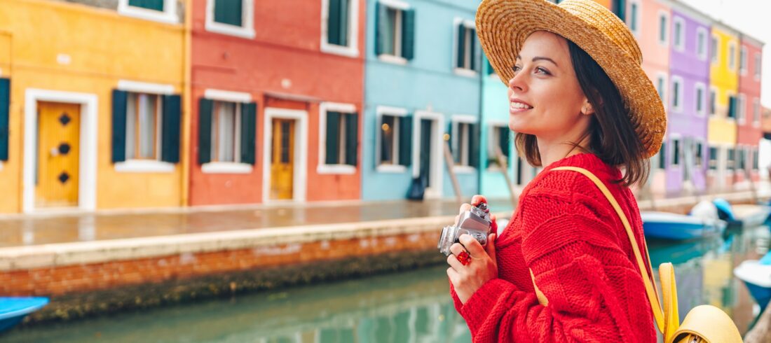 Beautiful young girl with a retro camera in Burano