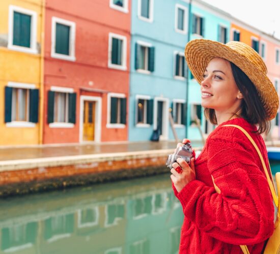 Beautiful young girl with a retro camera in Burano