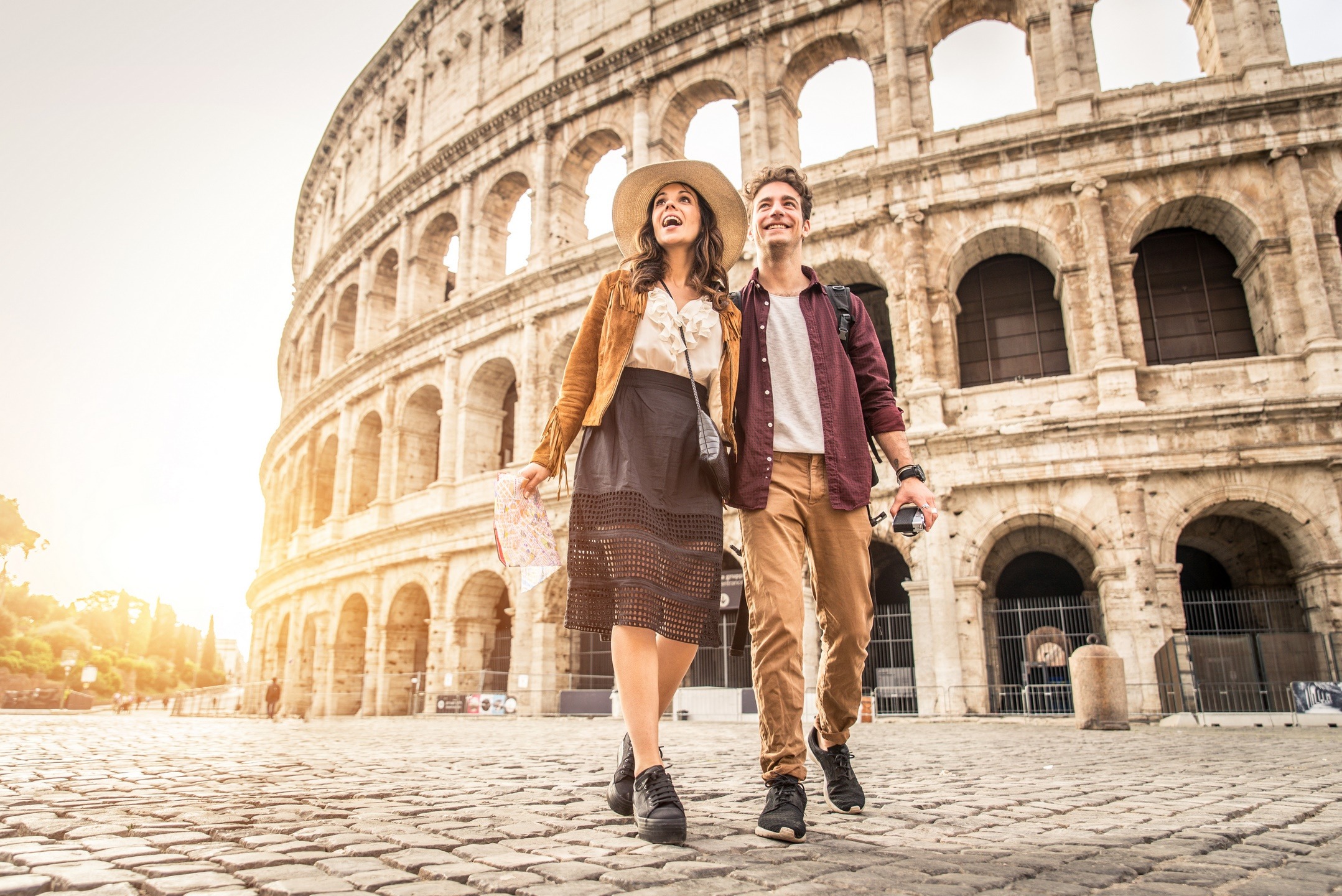 Young couple at the Colosseum, Rome - Happy tourists visiting italian famous landmarks